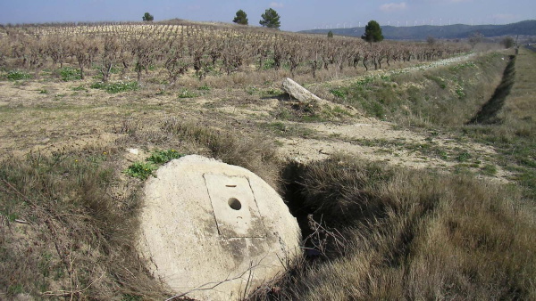 Fig. 19. Cruscades.	Couvercle du puits condamné et borne cadastrale sur la voie romaine.